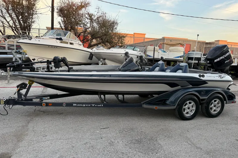 Slide: The Image of 2007 Ranger Z19 Comanche boat on trailer by the water, featuring a Mercury engine. - 3