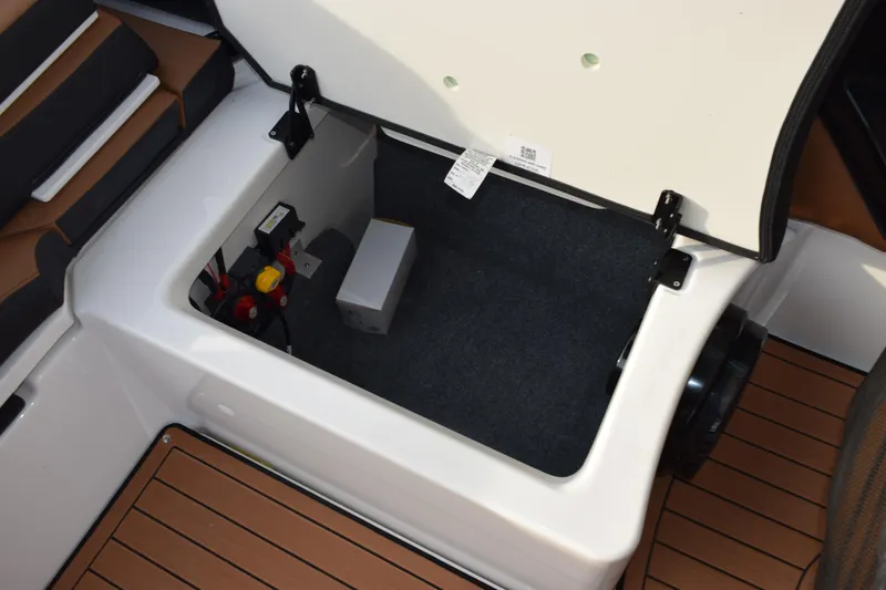 Slide: The Image of Open storage compartment in 2026 Yamaha Boats 252SD, featuring organized interior and electrical components. - 17