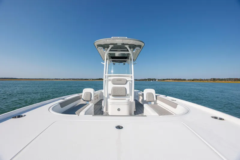 Slide: The Image of 2024 Caymas 26 HB boat on calm water under clear blue sky. - 12