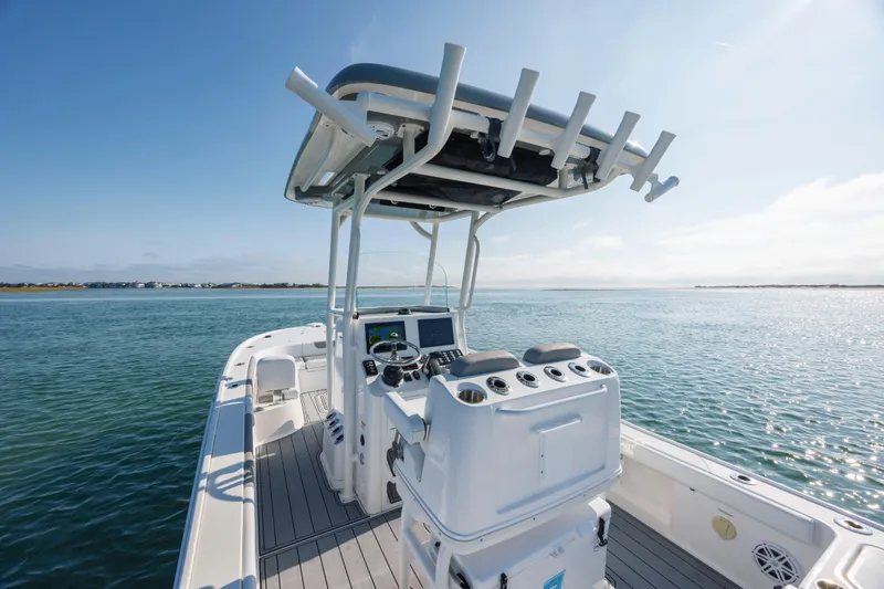 Slide: The Image of 2024 Caymas 26 HB boat on calm water, featuring a sleek helm and spacious deck. - 16