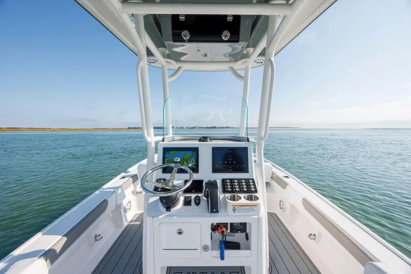Slide: The Image of 2024 Caymas 26 HB boat helm with modern controls on open water. - 18