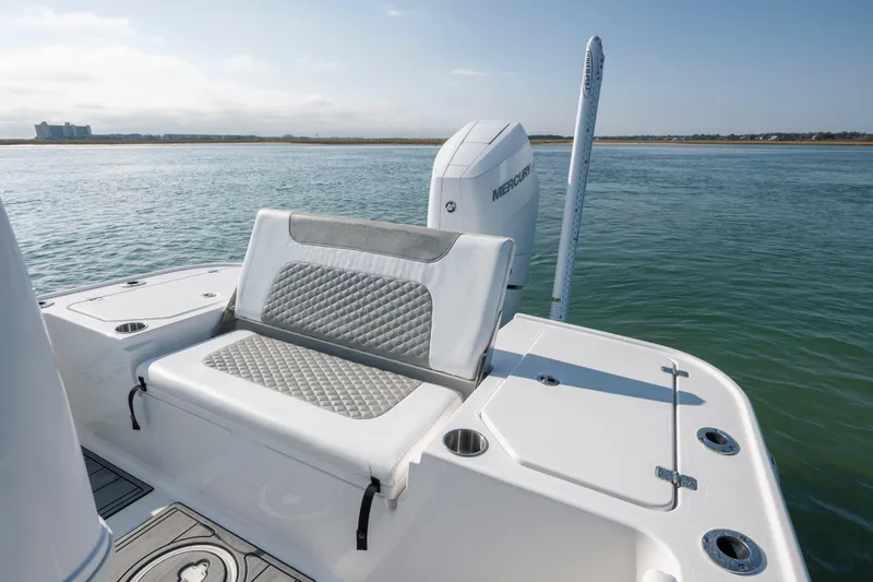 Slide: The Image of 2024 Caymas 26 HB boat with cushioned seating and Mercury engine on calm water. - 20