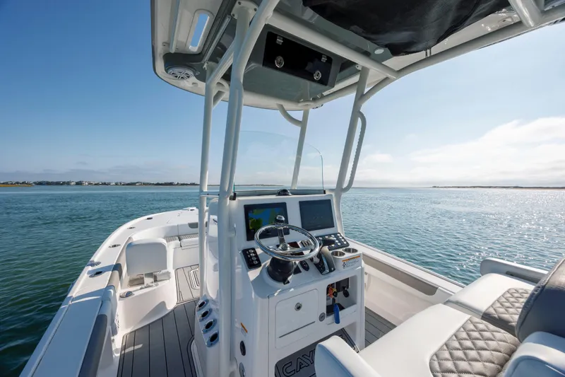 Slide: The Image of 2024 Caymas 26 HB boat interior with modern helm, navigating calm waters. - 22
