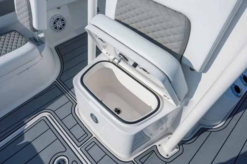 Slide: The Image of 2024 Caymas 26 HB boat interior with open storage compartment and cushioned seating. - 23