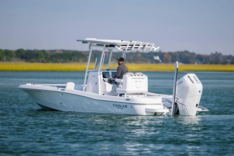 Slide: The Image of 2024 Caymas 26 HB boat on calm water, featuring a sleek design and powerful outboard motor. - 3
