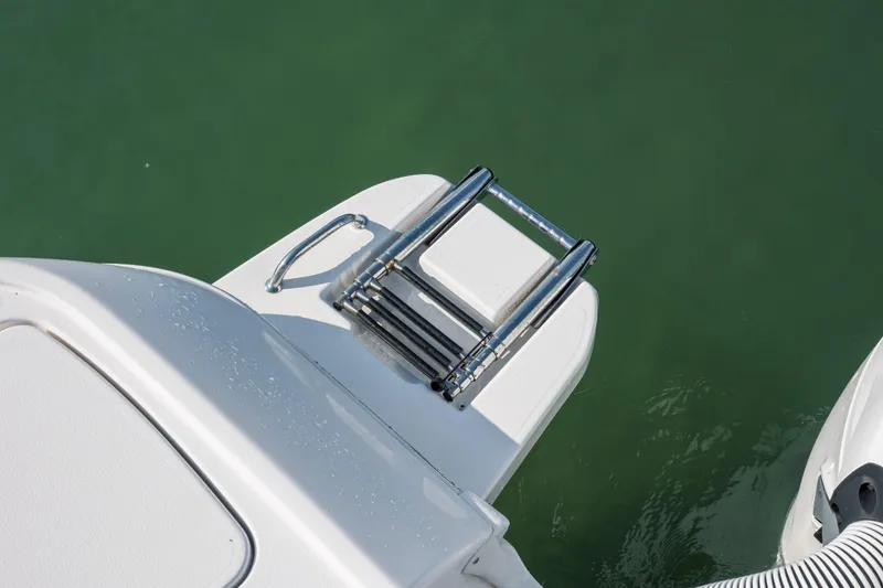 Slide: The Image of 2024 Caymas 26 HB boat swim platform with ladder over green water. - 30