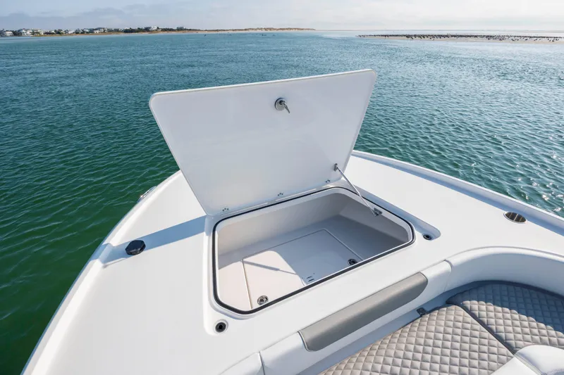Slide: The Image of 2024 Caymas 26 HB boat with open storage compartment on calm water. - 31