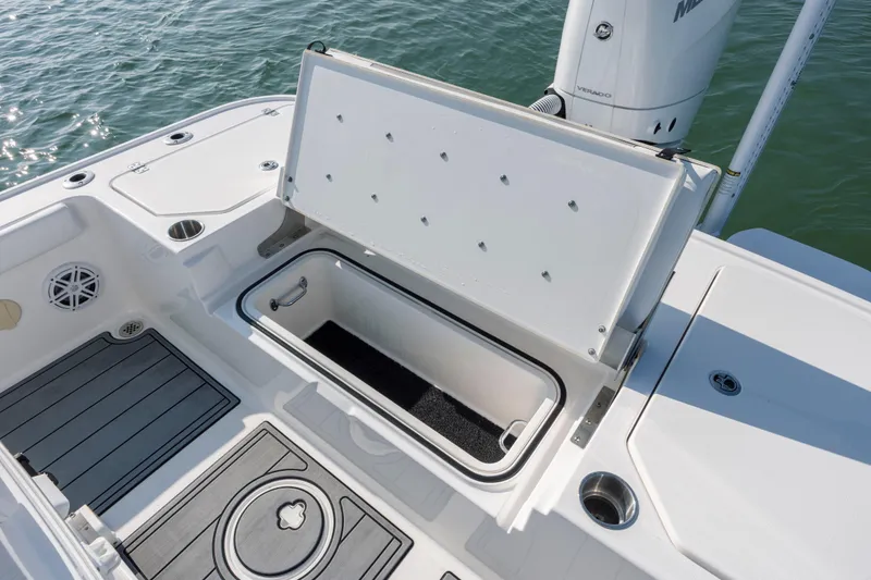 Slide: The Image of 2024 Caymas 26 HB boat with open storage compartment on deck, near water. - 35