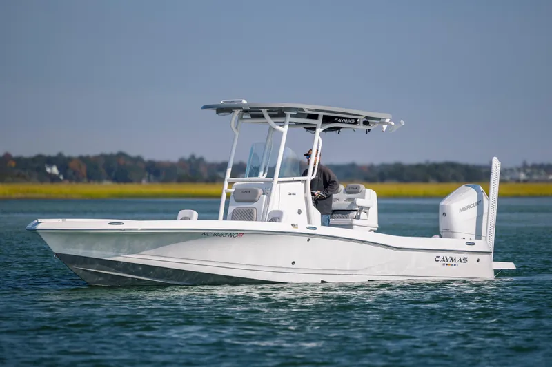 Slide: The Image of 2024 Caymas 26 HB boat cruising on calm water with scenic background. - 4