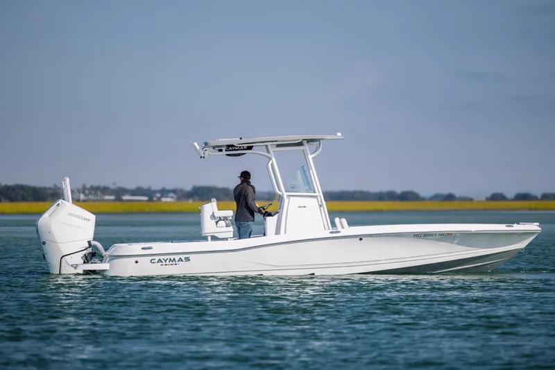 Slide: The Image of 2024 Caymas 26 HB boat on water, side view with Mercury engine. - 6