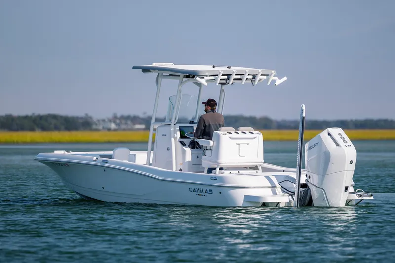 Slide: The Image of 2024 Caymas 26 HB boat cruising on calm water with a Mercury outboard engine. - 7