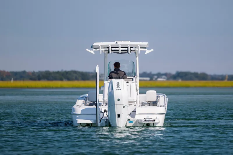 Slide: The Image of 2024 Caymas 26 HB boat cruising on calm water, rear view. - 8