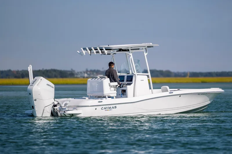 Slide: The Image of 2024 Caymas 26 HB boat cruising on calm water with a Mercury engine. - 9