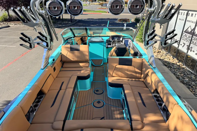 Slide: The Image of 2021 MasterCraft X26 boat interior with tan seating and teal accents. - 11