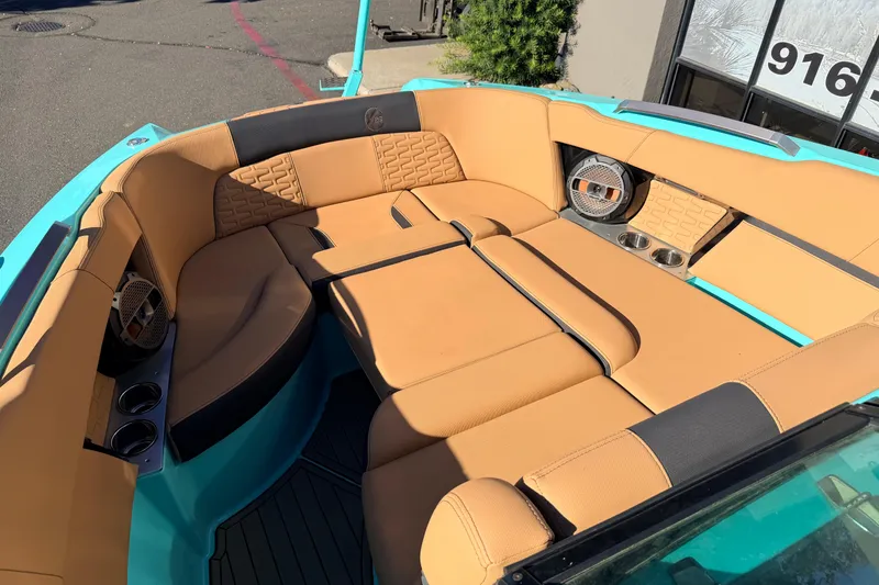Slide: The Image of 2021 MasterCraft X26 boat interior with tan seating and teal accents. - 21