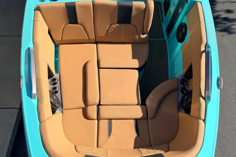 Slide: The Image of 2021 MasterCraft X26 boat interior with tan seating and teal accents. - 22