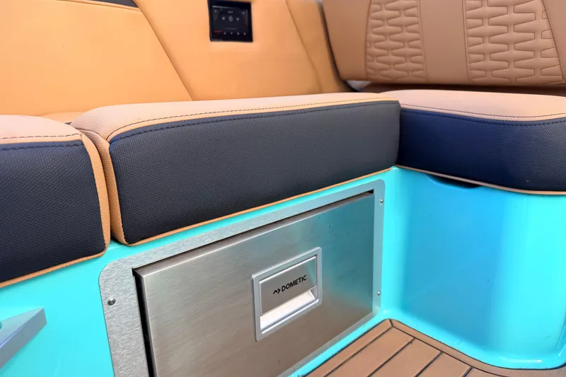 Slide: The Image of 2021 MasterCraft X26 interior with cushioned seating and Dometic cooler. - 24