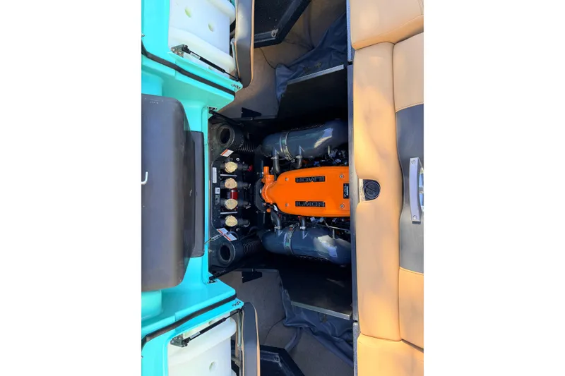 Slide: The Image of 2021 MasterCraft X26 engine compartment with orange engine cover and surrounding components. - 26