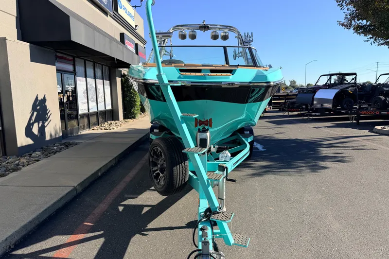 Slide: The Image of 2021 MasterCraft X26 boat on trailer, parked outside a building on a sunny day. - 3
