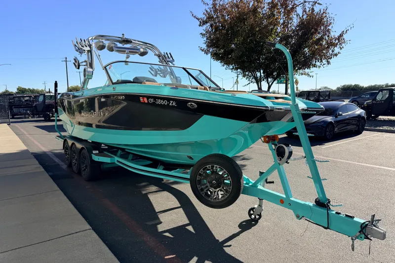 Slide: The Image of 2021 MasterCraft X26 boat on trailer in parking lot, sunny day. - 4