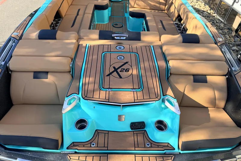 Slide: The Image of 2021 MasterCraft X26 boat interior with tan and turquoise seating and deck. - 9
