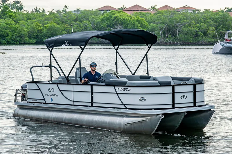 The Image of 2023 Veranda Relax VR22RFL pontoon boat cruising on a scenic lake. - 1