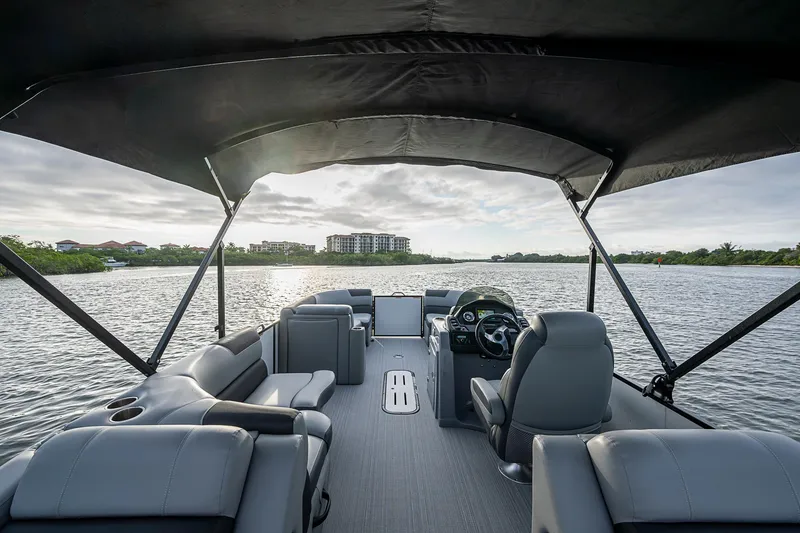 Slide: The Image of 2023 Veranda Relax VR22RFL pontoon boat interior with canopy on a scenic waterway. - 10