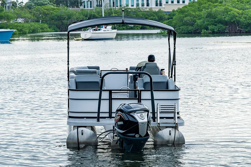 Slide: The Image of 2023 Veranda Relax VR22RFL pontoon boat on calm water, rear view with outboard motor. - 4
