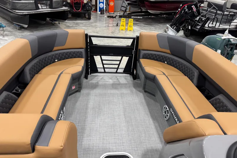 Slide: The Image of Interior of 2026 Sylvan L-5 boat with tan and gray seating in showroom. - 10