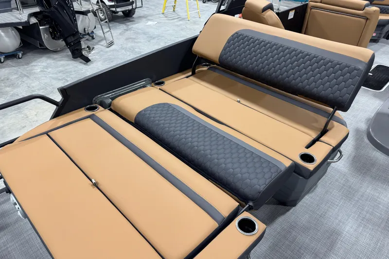 Slide: The Image of 2026 Sylvan L-5 boat interior with tan and gray cushioned seating and cup holders. - 13