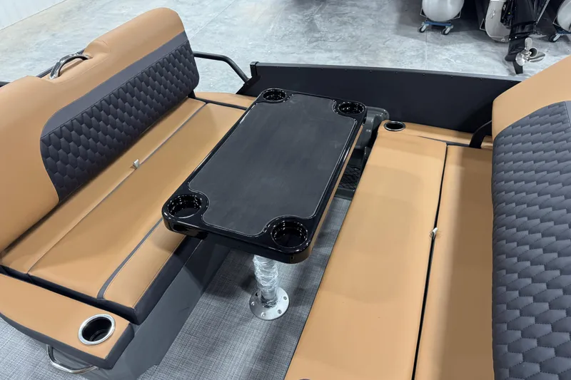 Slide: The Image of 2026 Sylvan L-5 boat interior with tan and black seating, featuring a central table. - 15