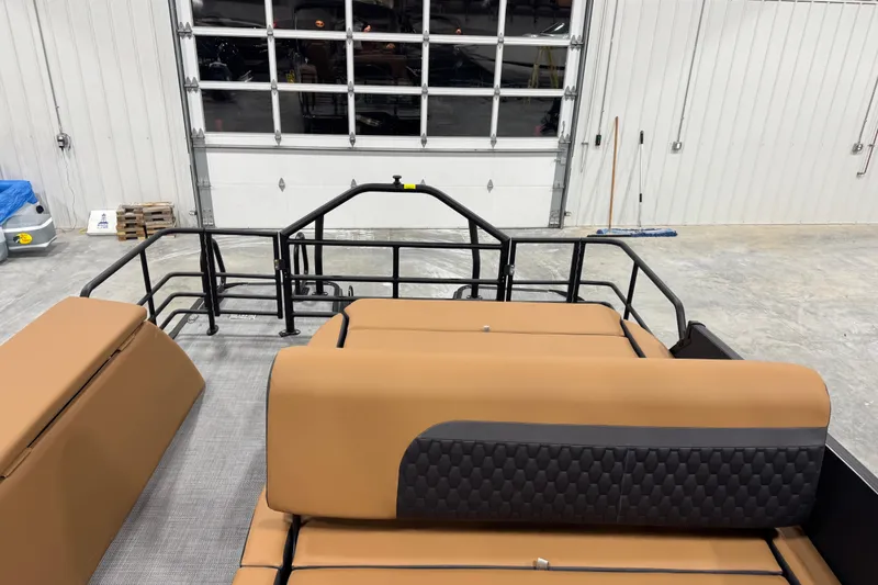 Slide: The Image of 2026 Sylvan L-5 boat interior with tan seating in a garage setting. - 8