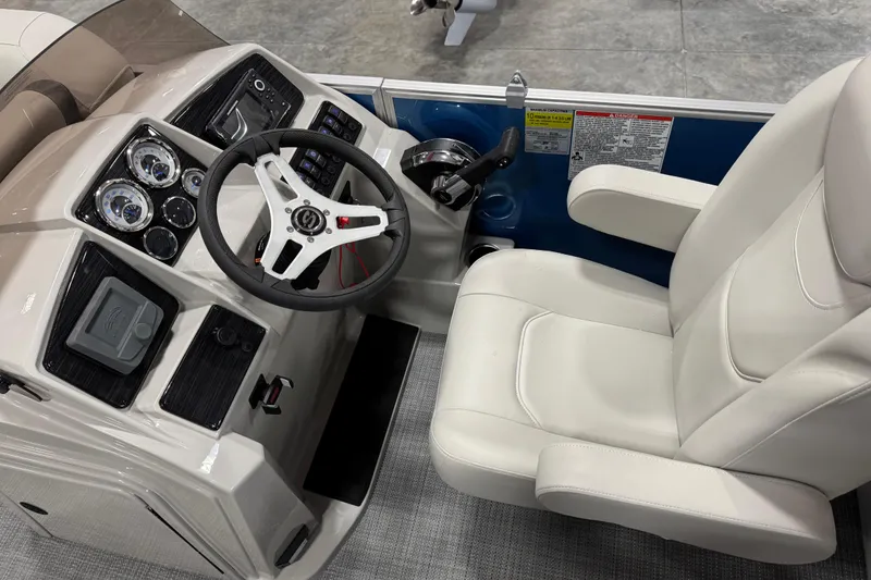 Slide: The Image of 2025 Sylvan 8522 Mirage boat cockpit with steering wheel and white captain's chair. - 10