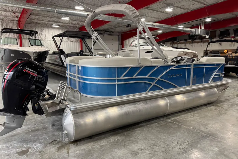 Slide: The Image of 2025 Sylvan 8522 Mirage pontoon boat with blue exterior in a showroom. - 3