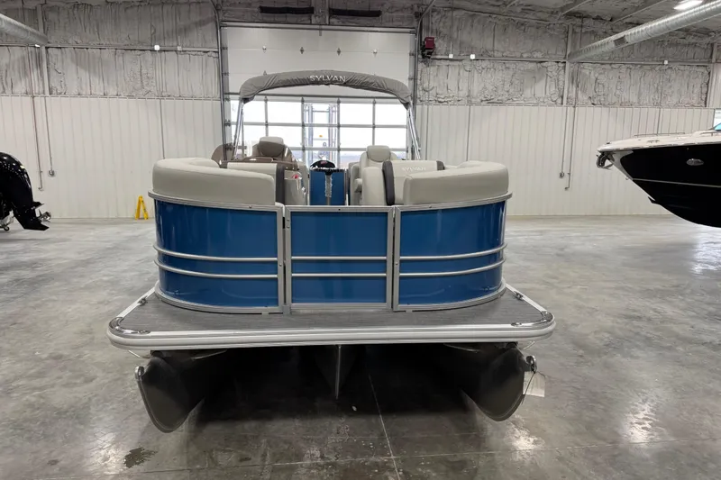 Slide: The Image of 2025 Sylvan 8522 Mirage pontoon boat in a spacious indoor showroom. - 6