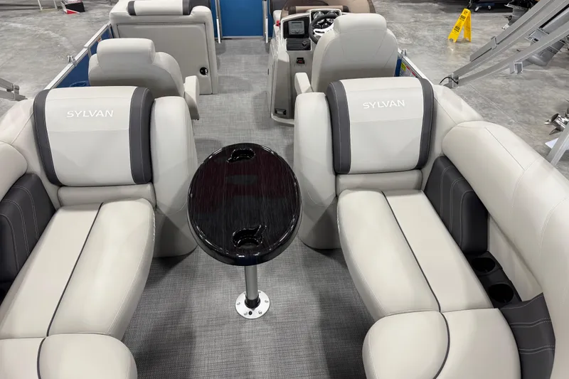 Slide: The Image of Interior of 2025 Sylvan 8522 Mirage pontoon boat with plush seating and central table. - 8