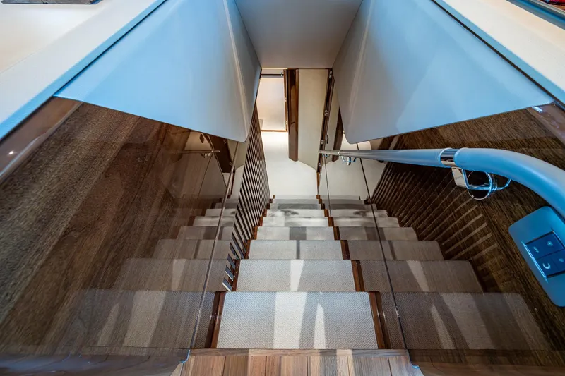 Slide: The Image of Staircase inside 2022 Princess X95 yacht, featuring sleek wood and modern design. - 38