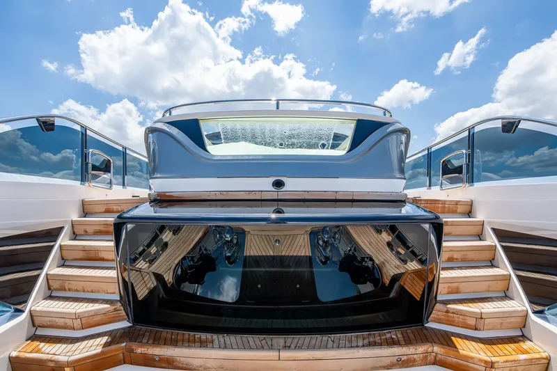 Slide: The Image of Luxury 2022 Princess X95 yacht with elegant wooden steps and sleek design under a blue sky. - 84