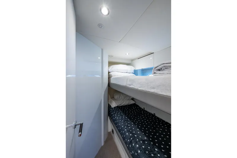 Slide: The Image of 2022 Princess X95 yacht interior with cozy bunk beds and modern lighting. - 97