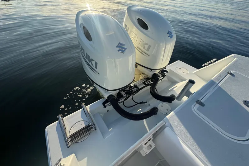 Slide: The Image of 1998 Contender 25 Open boat with dual Suzuki outboard motors on calm water. - 11