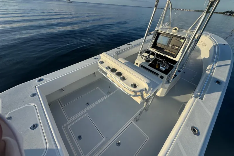 Slide: The Image of 1998 Contender 25 Open boat interior with console and seating, on calm water. - 12