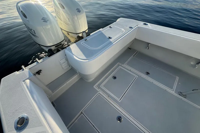 Slide: The Image of 1998 Contender 25 Open boat deck with dual Suzuki outboard engines on calm water. - 13
