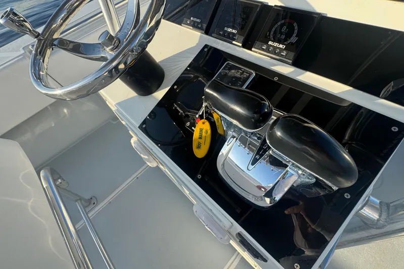 Slide: The Image of Steering console of 1998 Contender 25 Open boat with Suzuki controls and chrome wheel. - 14