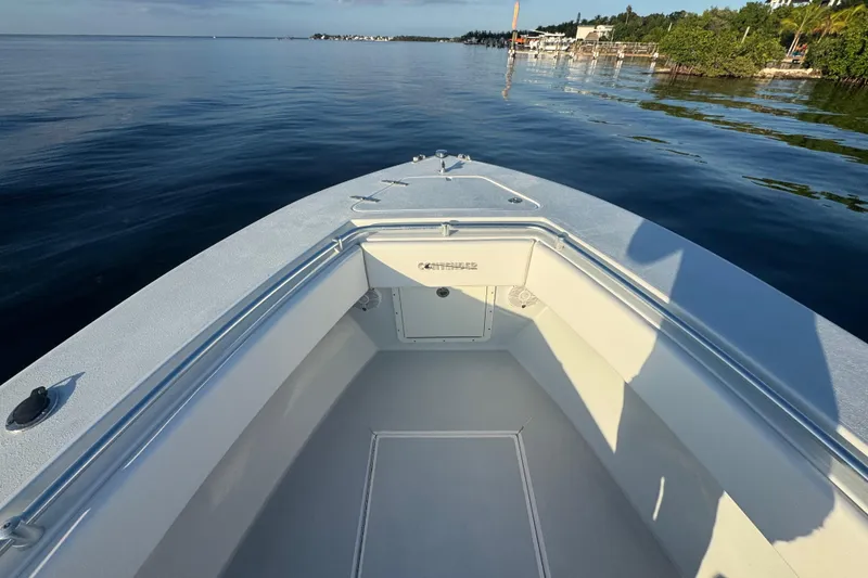 Slide: The Image of 1998 Contender 25 Open boat on calm water, showcasing spacious deck and sleek design. - 17