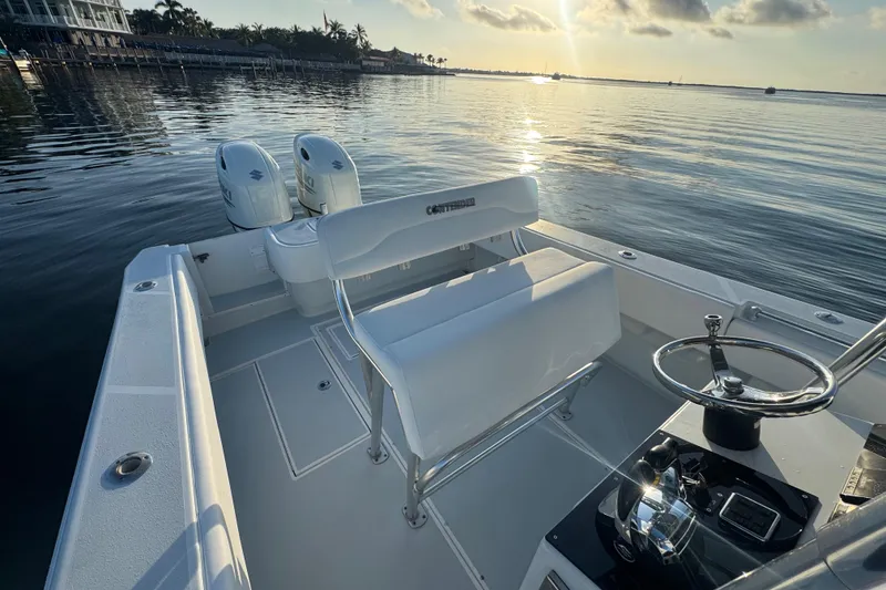 Slide: The Image of 1998 Contender 25 Open boat with dual engines on calm water at sunrise. - 19