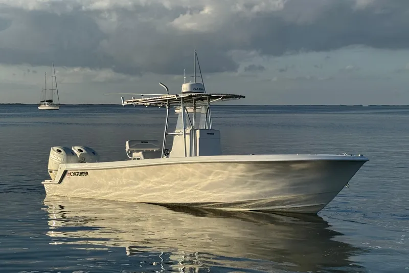 Slide: The Image of 1998 Contender 25 Open boat on calm water, featuring dual Suzuki engines. - 3
