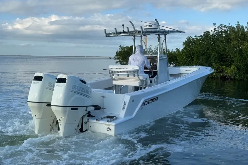 Slide: The Image of 1998 Contender 25 Open boat with dual Suzuki engines navigating coastal waters. - 4