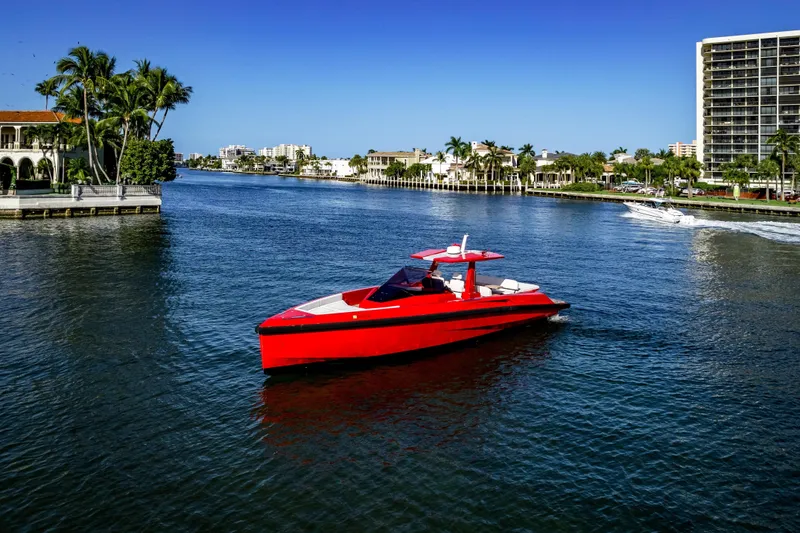 The Image of Red 2021 Wally 48ft yacht cruising on a sunny waterfront with palm trees. - 0