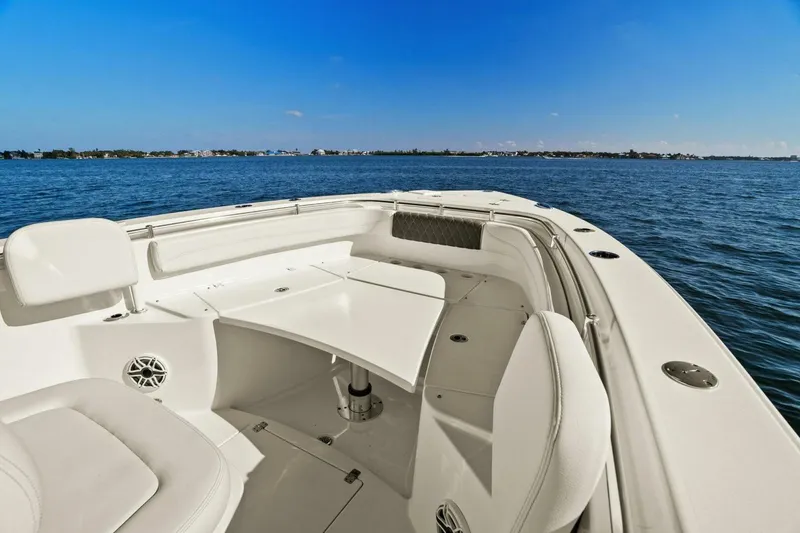 Slide: The Image of 2023 Cobia 301 Center Console boat on calm blue waters, featuring spacious seating. - 10