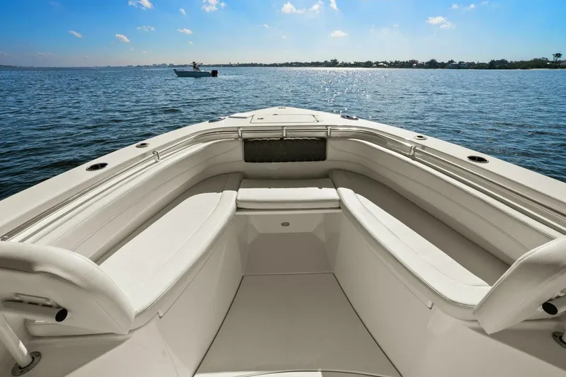 Slide: The Image of 2023 Cobia 301 Center Console boat interior with spacious seating on calm water. - 11
